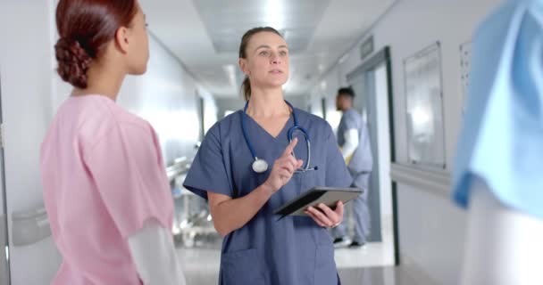 病院の廊下で看護師と話している白人看護師 彼らの会話は 臨床的な設定で医療の不可欠な部分であり スローモーション — ストック動画