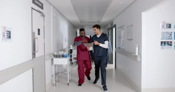 不同的医护人员在医院走廊讨论 他们专注于数字平板电脑 查看病人信息或医疗记录 慢动作 — 图库视频影像