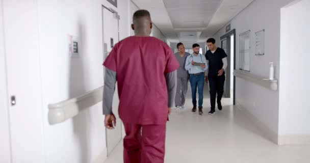Різноманітні Медичні Працівники Ходять Лікарняному Коридорі Вони Обговорюють Догляд Пацієнтами — стокове відео