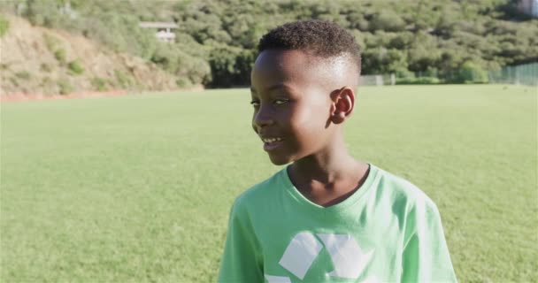 Ein Afroamerikanischer Junge Lächelt Auf Einem Sonnigen Außenplatz Und Trägt — Stockvideo