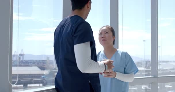 Nuori Aasialainen Terveydenhuollon Työntekijä Biracial Terveydenhuollon Työntekijä Keskustella Valoisassa Sairaalassa tekijänoikeusvapaata kuvapankin filmiä