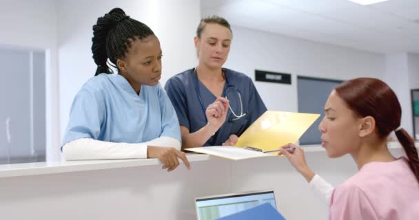 年轻的非裔美国人和白人医务工作者在医院审查文件 他们是专注于医疗专业人员 讨论病人信息 慢动作 — 图库视频影像