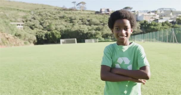 Çift Irklı Çocuk Futbol Sahasında Yeşil Geri Dönüşüm Tişörtü Giymiş — Stok video