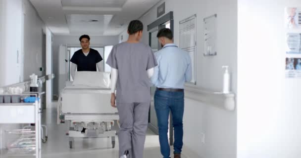 Hälso Och Sjukvårdspersonal Transporterar Patient Sjukhuskorridor Scenen Fångar Brådskande Och — Stockvideo
