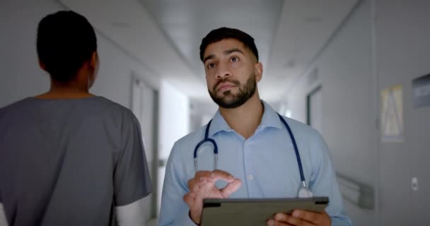 身穿医疗服的年轻亚洲医生在平板电脑上查看病人的数据 他把注意力集中在医院走廊的任务上 象征着他对医疗保健的奉献 缓慢的运动 — 图库视频影像