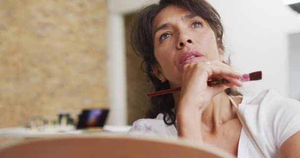Mujer Biracial Reflexiona Sobre Pintura Casa Expresión Reflexiva Sugiere Momento — Vídeo de stock
