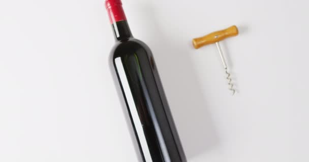 Una Bottiglia Vino Rosso Trova Accanto Cavatappi Una Superficie Bianca — Video Stock