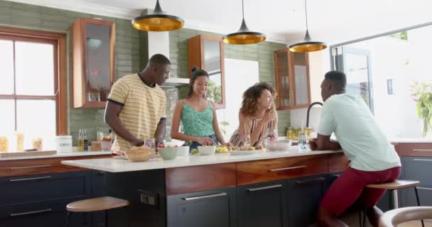 多样化的群体喜欢在现代化的家庭厨房里聊天 他们共享着一个轻松的时刻 周围都是新鲜的配料和明亮的装饰 缓慢的运动 — 图库视频影像