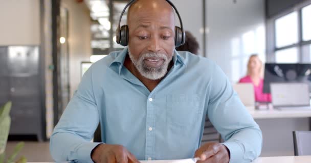 Επιχειρηματίας Αφροαμερικανός Εξετάζει Έγγραφα Ένα Γραφείο Έχει Επικεντρωθεί Στη Δουλειά — Αρχείο Βίντεο