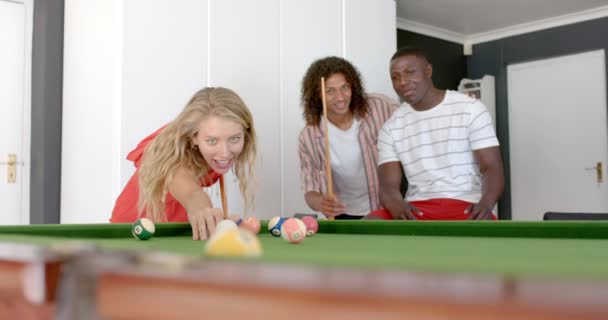 若い白人女性は 友人によって囲まれた自宅でプールをプレイします レジャータイムは 居心地の良い設定でフレンドリーなゲームを楽しんでいるトリオをキャプチャします スローモーション — ストック動画