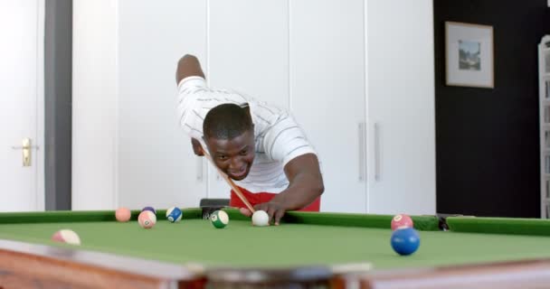 年轻的非裔美国人在家里打台球 他专注于在绿色台球桌上精确投篮 动作缓慢 — 图库视频影像
