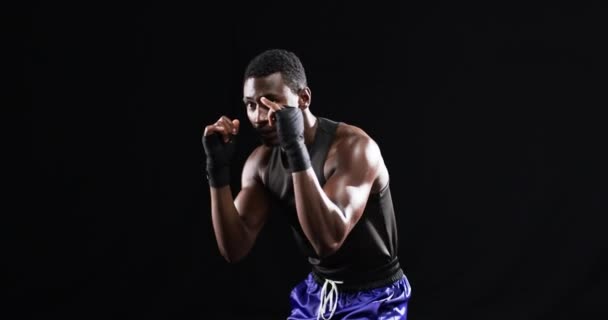 非洲裔美国拳击手在黑色背景下摆出战斗姿态 他的高度专注和运动形式表现出决心和力量 动作缓慢 — 图库视频影像