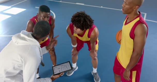 多样化的篮球队在体育馆里制定策略 教练在练习赛中与选手讨论战术 慢动作 — 图库视频影像