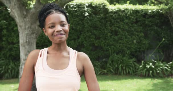 年轻的非洲裔美国妇女在户外度过了一个阳光灿烂的日子 有复制的空间 她那欢快的表情突出了花园的宁静氛围和缓慢的动作 — 图库视频影像