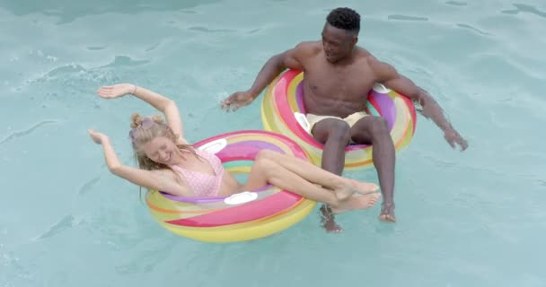 아프리카계 미국인 남성과 코카서스 여성은 수영장을 있습니다 그들은 부유물에 놀라운 — 비디오