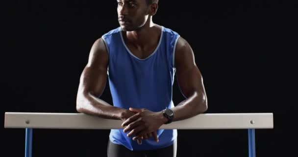 Αφροαμερικανός Αθλητής Που Αναπαύεται Στα Εμπόδια Μαύρο Φόντο Εστιασμένη Έκφραση — Αρχείο Βίντεο