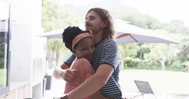 一对多样化的夫妇 一个年轻的非洲裔美国女人和一个白人男人在家里拥抱 他们亲切的拥抱暗示了他们在家庭生活中的一种舒适和关爱的关系 一种慢动作 — 图库视频影像