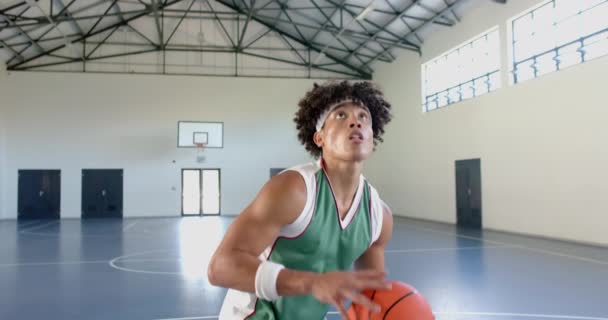 Joven Hombre Biracial Practica Baloncesto Una Cancha Cubierta Enfoque Perfeccionamiento — Vídeo de stock