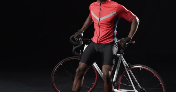 Afro Amerikai Kerékpáros Magabiztosan Pózol Egy Fekete Hátterű Kerékpáron Fénymásoló — Stock videók