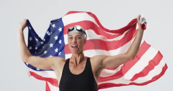 年轻的白人女游泳运动员庆祝胜利 她拿着美国国旗散发着喜悦和爱国心 动作缓慢 — 图库视频影像