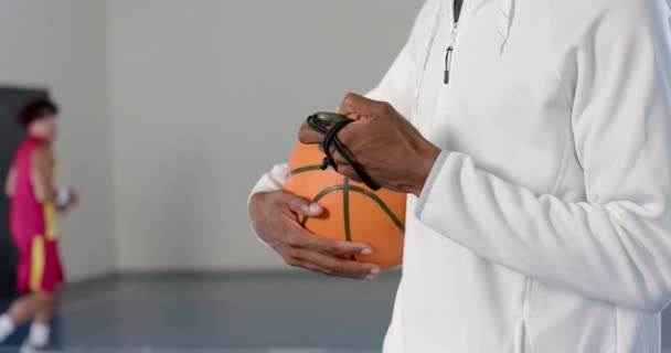 非洲裔美国人的教练把一个篮球放在室内 有复制的空间 他对球的专注和紧紧抓住暗示他要准备一场比赛或训练 慢动作 — 图库视频影像