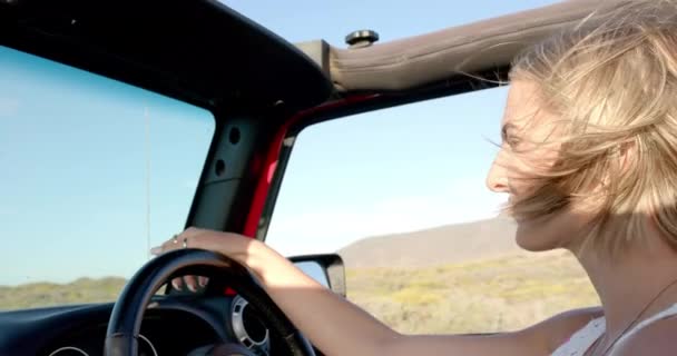 若い白人女性は コピースペース付きのロード旅行でコンバーチブルでドライブを楽しんでいます 彼女のリラックスしたDemeanorは ゆったりとした一日を提案します ゆっくりとした動き — ストック動画