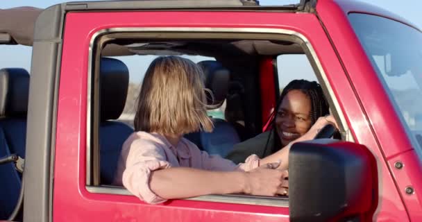 年轻的非洲裔美国女人和年轻的白人女人在路上的汽车里分享着同一个笑声 还有复制的空间 他们快乐的互动凸显了一个自发的时刻 — 图库视频影像