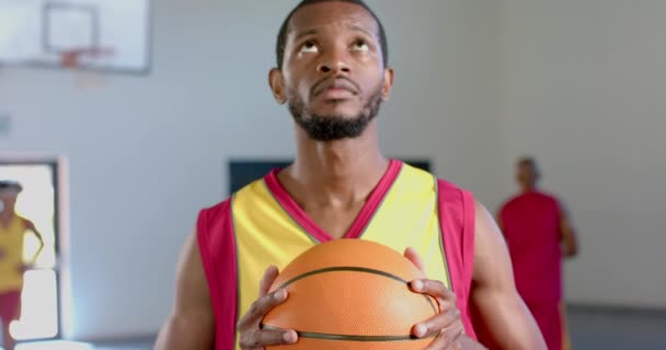 Uomo Afroamericano Tiene Una Palla Basket Palestra Sua Espressione Focalizzata — Video Stock