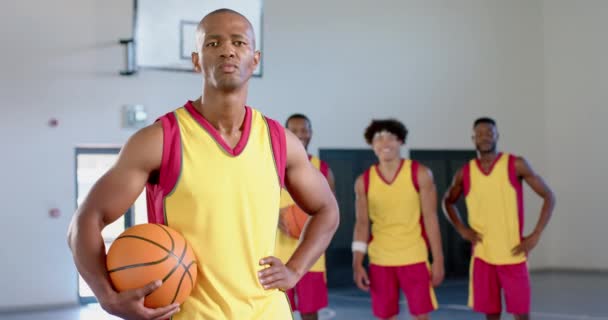 Afroamerykanin Trzyma Piłkę Siłowni Koledzy Drużyny Tle Sugerują Trening Koszykówki — Wideo stockowe