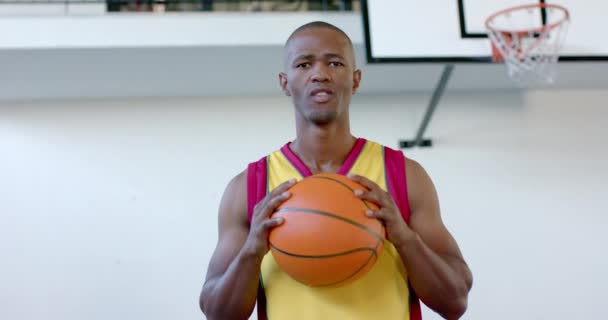 Hombre Afroamericano Sostiene Una Pelota Baloncesto Gimnasio Atuendo Deportivo Sugiere — Vídeo de stock