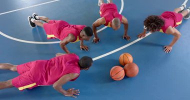 Basketbol sahasındaki Afrikalı Amerikalı erkekler. Bir araya toplanmışlar, oyun başlamadan önce strateji kuruyorlar, ağır çekimde..