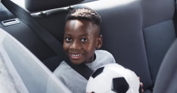 Afro Amerikaanse Jongen Glimlacht Achterbank Van Een Auto Terwijl Hij — Stockvideo