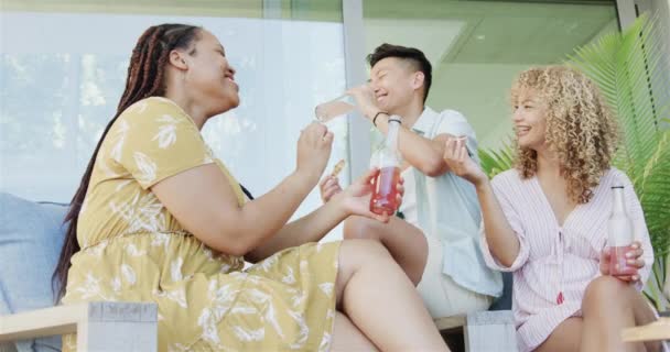 年轻的亚洲男人和女人喜欢在家里愉快地交谈 他们在一个轻松的 阳光灿烂的客厅里 在一个慢动作中分享欢笑和饮料 — 图库视频影像