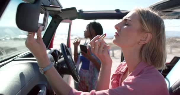 코카서스 여성은 여행에 립스틱을 적용합니다 아프리카계 미국인 차량에서 전망을 즐기는 — 비디오