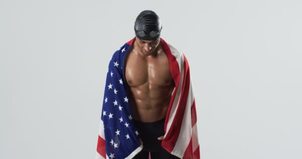 田径运动员游泳运动员打着美国国旗庆祝胜利 他的骄傲和喜悦在工作室里回荡 展示了他的成就 慢动作 — 图库视频影像