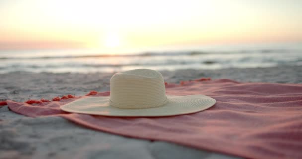 日落时 一顶多样化的太阳帽躺在沙滩毛巾上 并留有复制空间 拍摄一个宁静的海滩场景 建议放松或放暑假 慢动作 — 图库视频影像