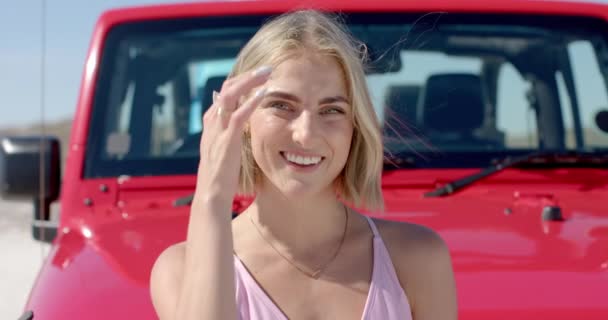 若い白人女性は 道路の旅で赤い車の前で明るく微笑んでいる 彼女の喜びの表情は 屋外の設定に活気に満ちた雰囲気を追加し ゆっくりとした動き — ストック動画