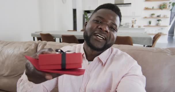아프리카계 미국인 남자가 집에서 통화로 선물을 제공합니다 아프리카계 미국인 남자가 — 비디오