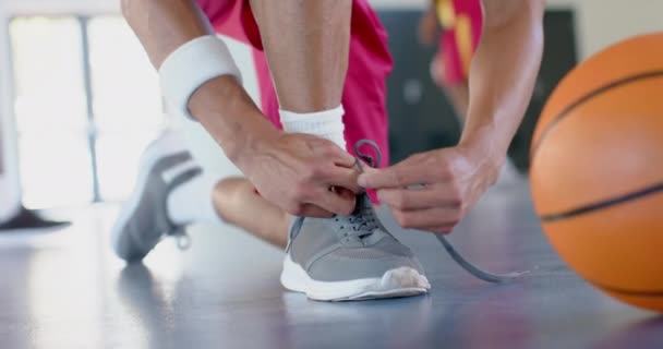 运动员在室内场地上绑鞋带 篮球比赛前的准备工作强调了适当的装备 慢动作的重要性 — 图库视频影像
