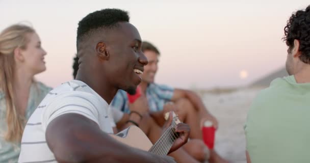 Молодий Афроамериканський Чоловік Грає Гітарі Пляжі Збираючись Вечірці Друзі Насолоджуються — стокове відео