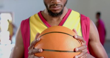 Spor salonunda elinde basketbol topu tutan odaklanmış Afro-Amerikan bir adam. Konsantrasyonu bir oyuna ya da antrenman oturumuna hazırlanmasını öneriyor..