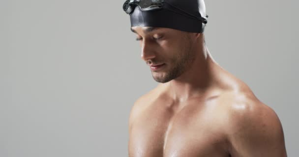 水泳用ゴーグルを着用した若手スポーツ選手 コピースペース 彼の焦点を絞った表現は 競争のための決意と準備 ゆっくりとした動きを示唆しています — ストック動画