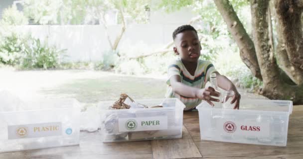 アフリカ系アメリカ人の少年は コピースペースと屋外のリサイクル材料を種類します — ストック動画