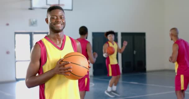 Young African American Man Holds Basketball Gym Copy Space Teammates — Stock Video