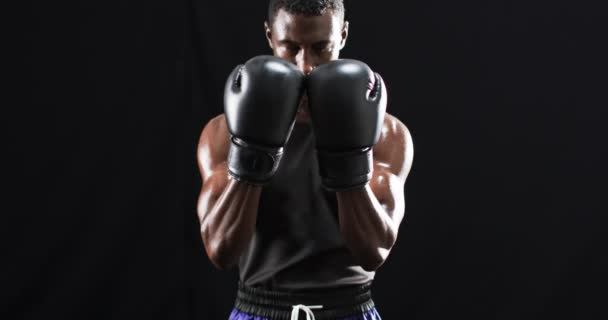 非洲裔美国拳击手在黑色背景上摆出防御姿态 他在体育馆里表现出专注和决心 慢动作 — 图库视频影像