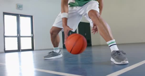 Joven Birracial Juega Baloncesto Interior Atletismo Brilla Mientras Gotea Pelota — Vídeos de Stock
