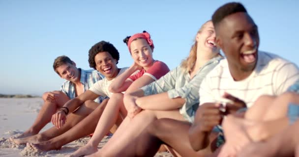 各色人等的朋友们一起享受海滩日 当他们在沙滩上放松 慢动作时 笑声和粘合是显而易见的 — 图库视频影像