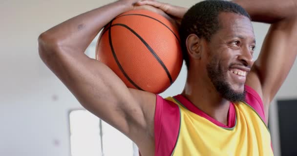 Egy Afro Amerikai Férfi Pózol Egy Kosárlabdával Edzőteremben Örömteli Kifejezése — Stock videók