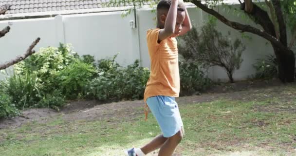 Afroamerikansk Pojke Spelar Utomhus Njuter Solig Dag Bakgård Full Ungdomlig — Stockvideo