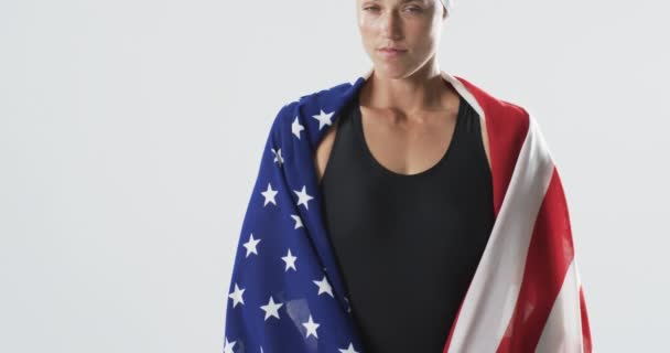 身穿美国国旗的年轻白种人女运动员自信地站在那里 经过一场比赛 她代表着一位以民族自豪感为荣的游泳运动员 动作缓慢 — 图库视频影像